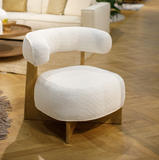 A white upholstered armchair with a solid wood frame, featuring a modern design with a distinct angular cutout on the backrest.